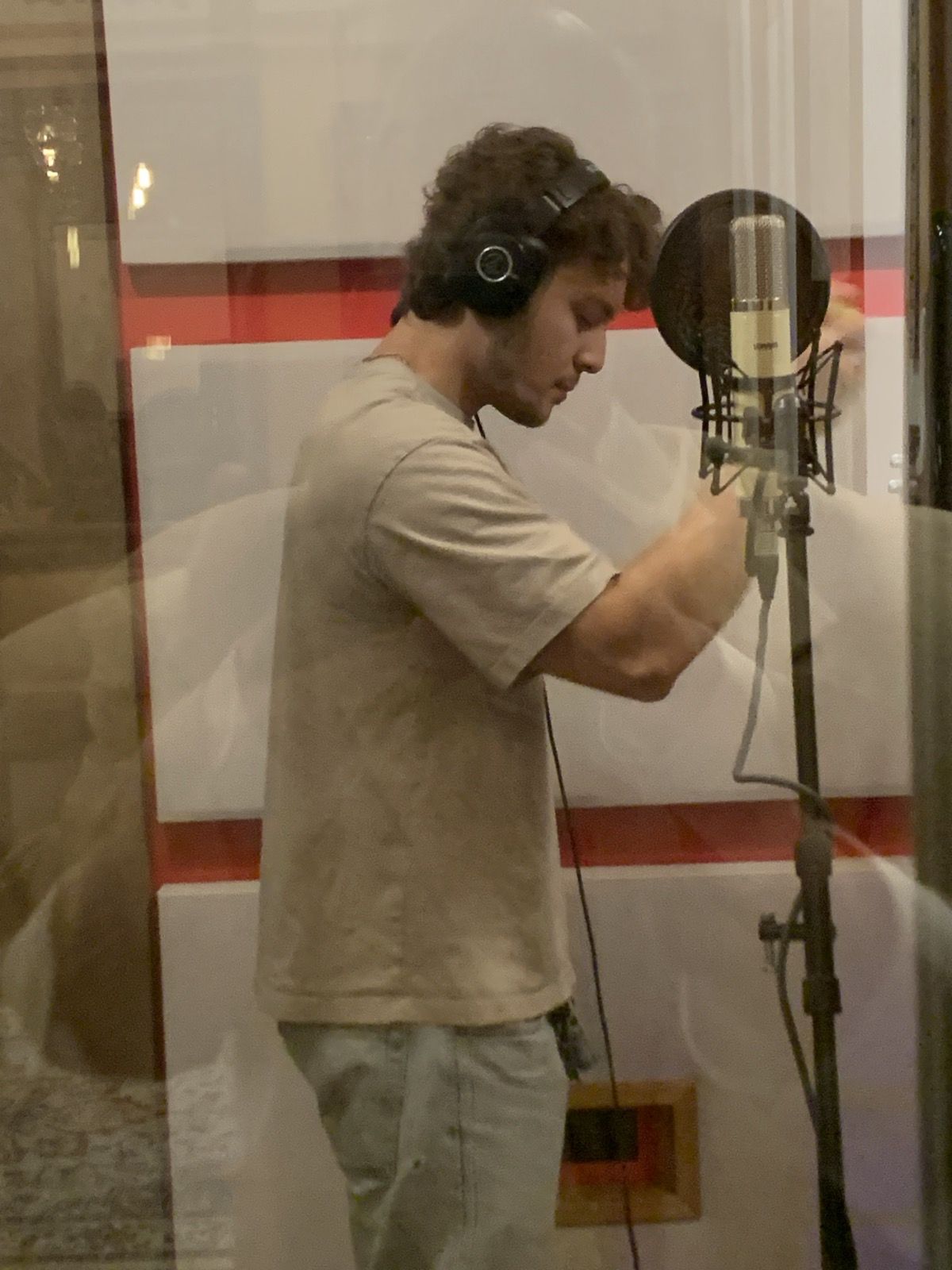 A vocalist recording at the condenser microphone.