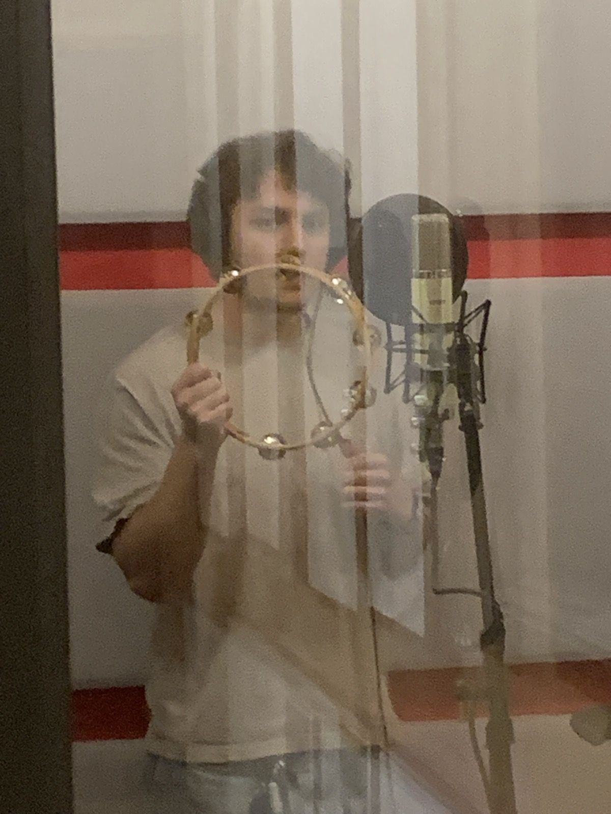 A vocalist behind the booth glass.
